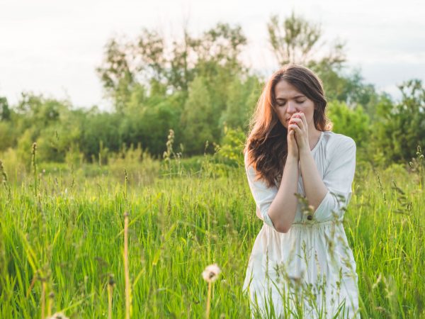 Young woman praying to receive help from Life First after a regretted abortion decision.